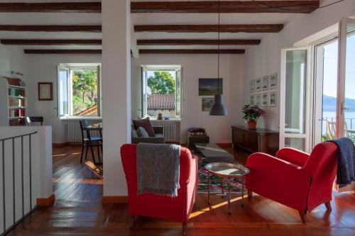 a living room with red chairs and a table at Cadebei in Oggebbio