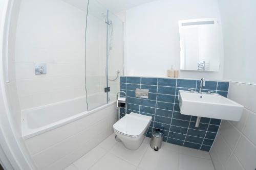 een badkamer met een toilet, een wastafel en een douche bij 2 Putsborough - Luxury Apartment at Byron Woolacombe, only 4 minute walk to Woolacombe Beach! in Woolacombe