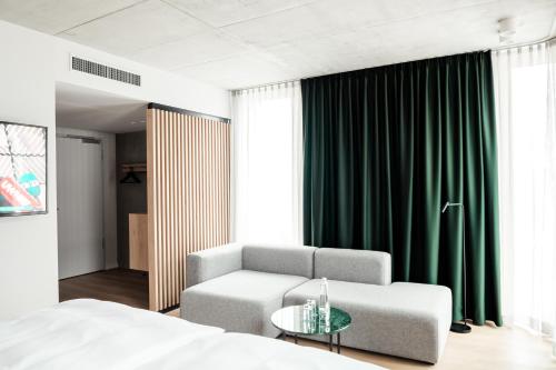 a bedroom with a bed and a chair and a table at Coreum Hotel in Stockstadt am Rhein