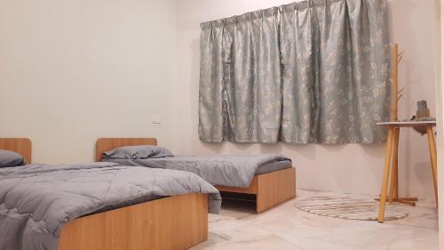 een kamer met 2 bedden en een raam bij BRICK HOMESTAY in Teluk Intan