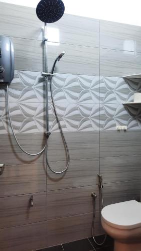 a shower in a bathroom with a toilet at BRICK HOMESTAY in Teluk Intan