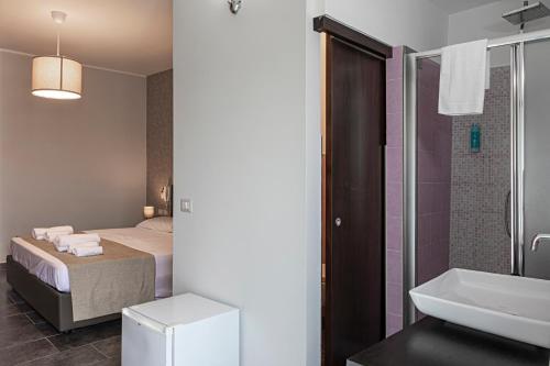 een badkamer met een bed, een douche en een wastafel bij B&B Bellavista in Margherita di Savoia