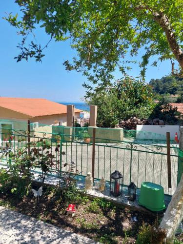 a fence with a garden in front of a house at Evanthie Studio in Poros