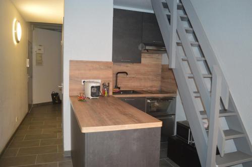 une cuisine avec un comptoir, un évier et un escalier dans l'établissement Espace 43, Sète Corniche Plage, à Sète