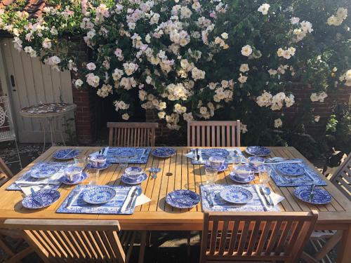 サックスマンダムにあるCrown House Great Glemhamの木製テーブル(花の入った青い皿付)