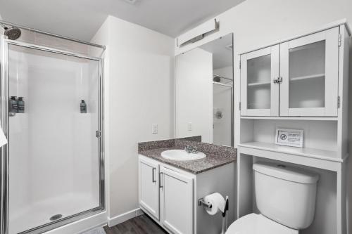 a bathroom with a toilet and a sink and a shower at 2BR 2BA In The Block Apartment by CozySuites in Indianapolis