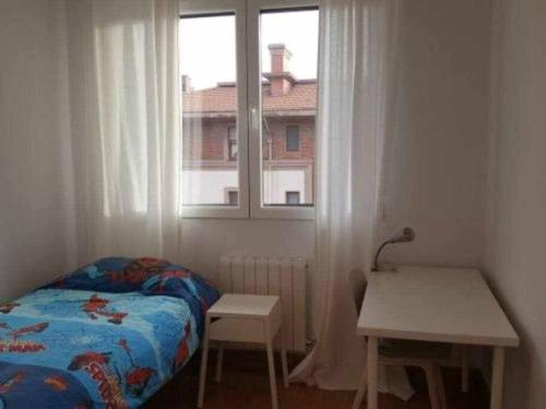 a small bedroom with a bed and a window at Bilbao luminoso y bien ubicado in Bilbao
