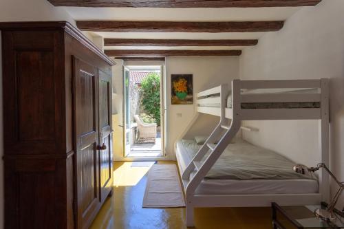 a bedroom with a bunk bed and a door to a patio at Cadebei in Oggebbio