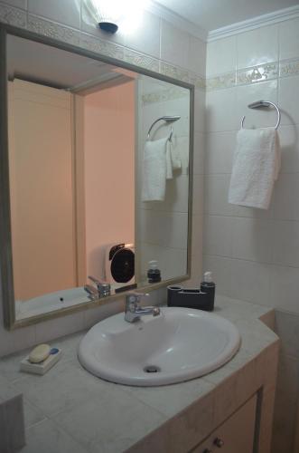 a bathroom with a sink and a mirror at Not a Villa in Roussospítion