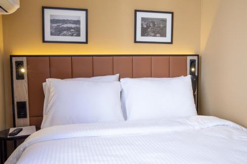 a bed with two white pillows and two pictures on the wall at EA Exclusive Hotel in Istanbul