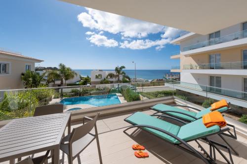 balcón con mesa y sillas y piscina en Porto de Mós 72 by Destination Algarve en Lagos