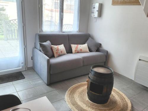 uma sala de estar com um sofá e um barril em studio mezzanine avec terrasse em Saint-Julien-de-Concelles