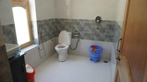 a small bathroom with a toilet and a window at Natures View Residency in Hundar