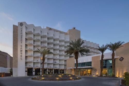 un hôtel avec des palmiers devant un bâtiment dans l'établissement Herbert Samuel Hod Dead Sea Hotel, à Ein Bokek
