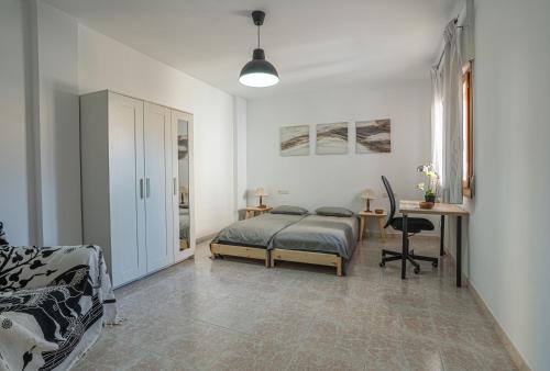 1 dormitorio con cama y escritorio en Casa Granada budget Haus bei Granada, en Dúrcal