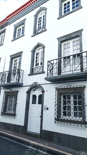 a white building with a white door and windows at Colégio 86 in Ponta Delgada