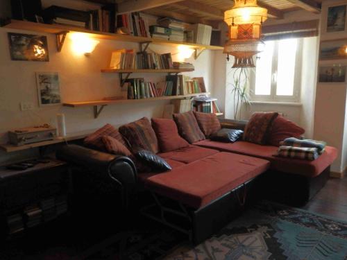 a living room with a red couch and a table at @gatetothewild in Coreglia Ligure