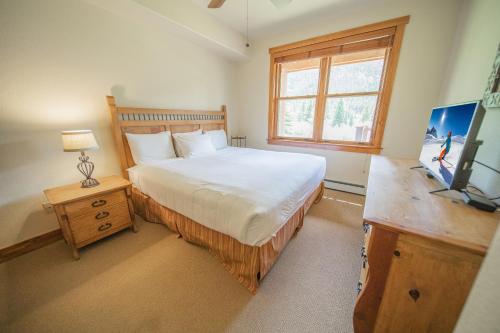 um quarto com uma cama grande e uma janela em Red Hawk Townhomes 2352 em Keystone