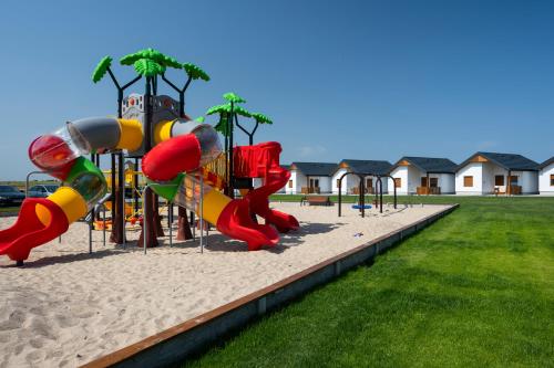 a playground with a slide in the sand at Kwiat Paproci in Gąski