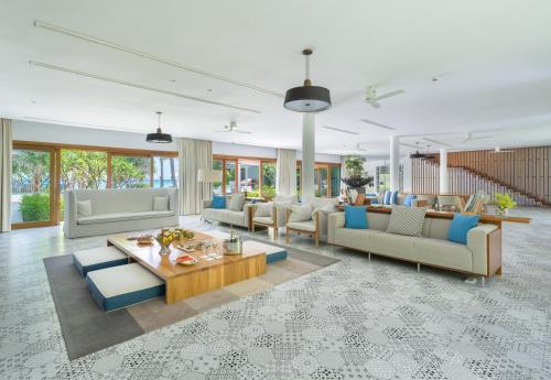 a large living room with couches and a table at Amilla Maldives in Kihaadhoo