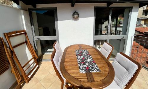 a wooden table and chairs on a balcony at Casa Via Vezzargo in Badalucco