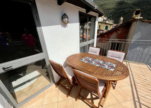 a wooden table and chairs on a balcony at Casa Via Vezzargo in Badalucco