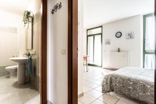 een slaapkamer met een bed en een badkamer met een wastafel bij Casa dei fiori monolocale in Iesi