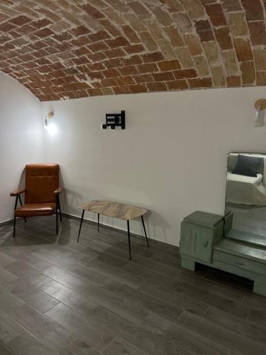 a room with a table and a chair and a brick wall at Agriturismo Quartuccio in Oricola