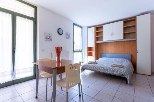 een slaapkamer met een bed en een tafel en stoelen bij Casa dei fiori monolocale in Iesi