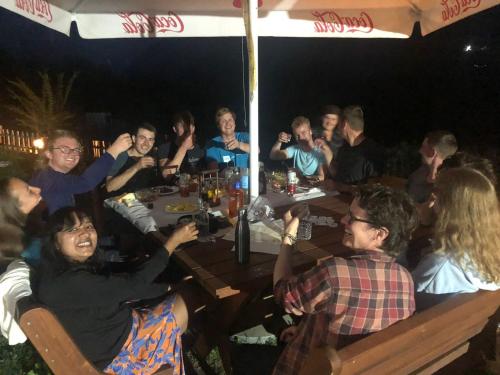 un grupo de personas sentadas en una mesa por la noche en Guest House Rrashkadoli, en Theth