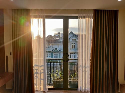 a window with a view of a building at GREENECO DA LAT HOTEL - Khách sạn Green Eco Đà Lạt in Da Lat