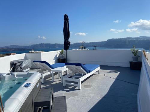 a patio with chairs and a hot tub on a roof at Villa Solasta in Santorini in Akrotiri