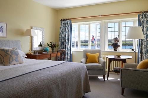 a bedroom with a bed and two chairs and a window at Hotel Tresanton in Saint Mawes