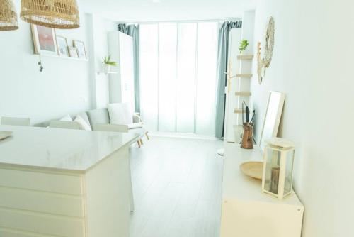 ein weißes Wohnzimmer mit einem Schreibtisch und einem Stuhl in der Unterkunft Lindamar Canteras Beach House in Las Palmas de Gran Canaria