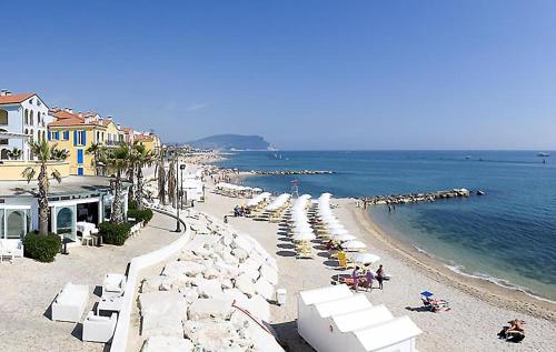 a beach with a bunch of chairs and the ocean at Casa Antica a 10 metri dalla Spiaggia con giardino interno in Porto Recanati