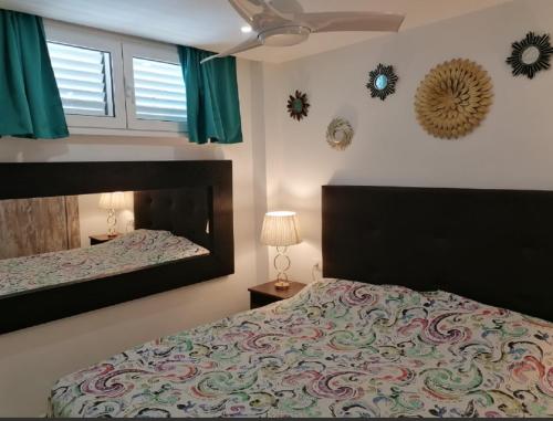 a bedroom with a large bed and a mirror at Mama Yumbo in Playa del Ingles