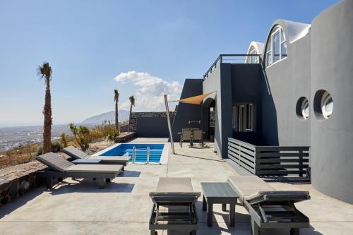a villa with a view of a swimming pool at Theano Cave Suites & Villas in Imerovigli