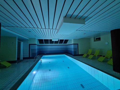 a large swimming pool in a building with a ceiling at Villa a cappella in Binz