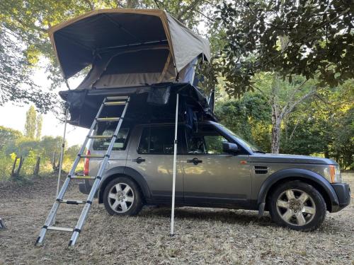 um camião com uma tenda em cima dele em Landrover with luxury roof tent em Croydon