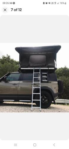 a truck with a roof rack on the back of it at Landrover with luxury roof tent in Croydon