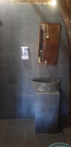 ein Bad mit einem Waschbecken und einem Spiegel in der Unterkunft High villa in Batununggul