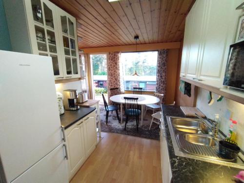 una cucina con lavandino e una sala da pranzo con tavolo di Punkaharju Savonlinna, perheasunto, Family home a Savonlinna