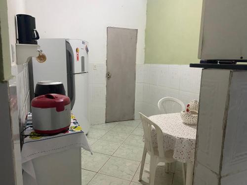 uma pequena cozinha com uma mesa e um frigorífico em Espaço Verde em Vitória