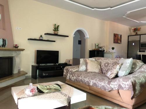 a living room with a couch and a tv at Milos Apartments in Himare