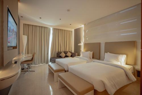 a hotel room with two beds and a desk at Alberni Jabal Hafeet Hotel Al Ain in Al Ain