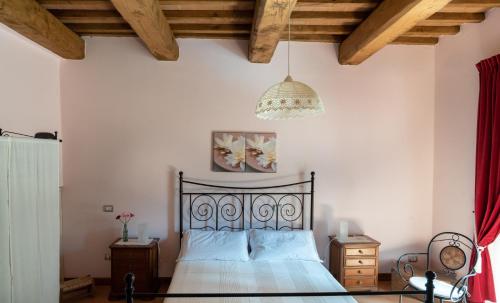 a bedroom with a bed and a chandelier at Bed & Breakfast l'Albergo Di Ieri in Serravalle di Chienti