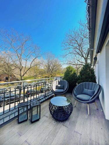 two chairs and a table on a deck with a view at Hotel du Nord, Hamburg-Volksdorf in Hamburg