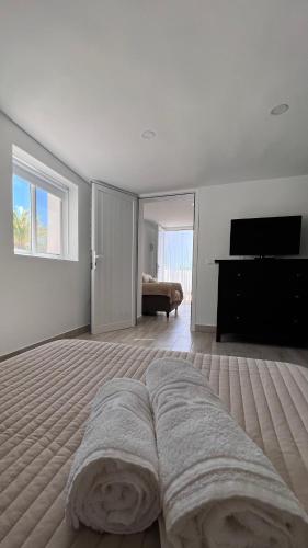 a white bedroom with a bed and a piano at Salobre Blue Sky 2 in Salobre