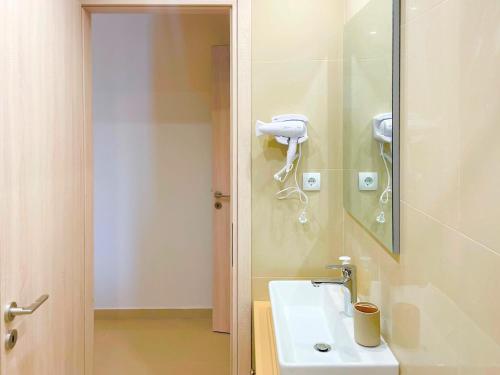 ein Badezimmer mit einem Waschbecken und einem Telefon an der Wand in der Unterkunft Lefkada house with private yard parking 2 in Nydri