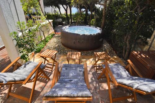 a patio with a hot tub and chairs and a pool at Family Holiday house - 50 m to the beach! in Kožino